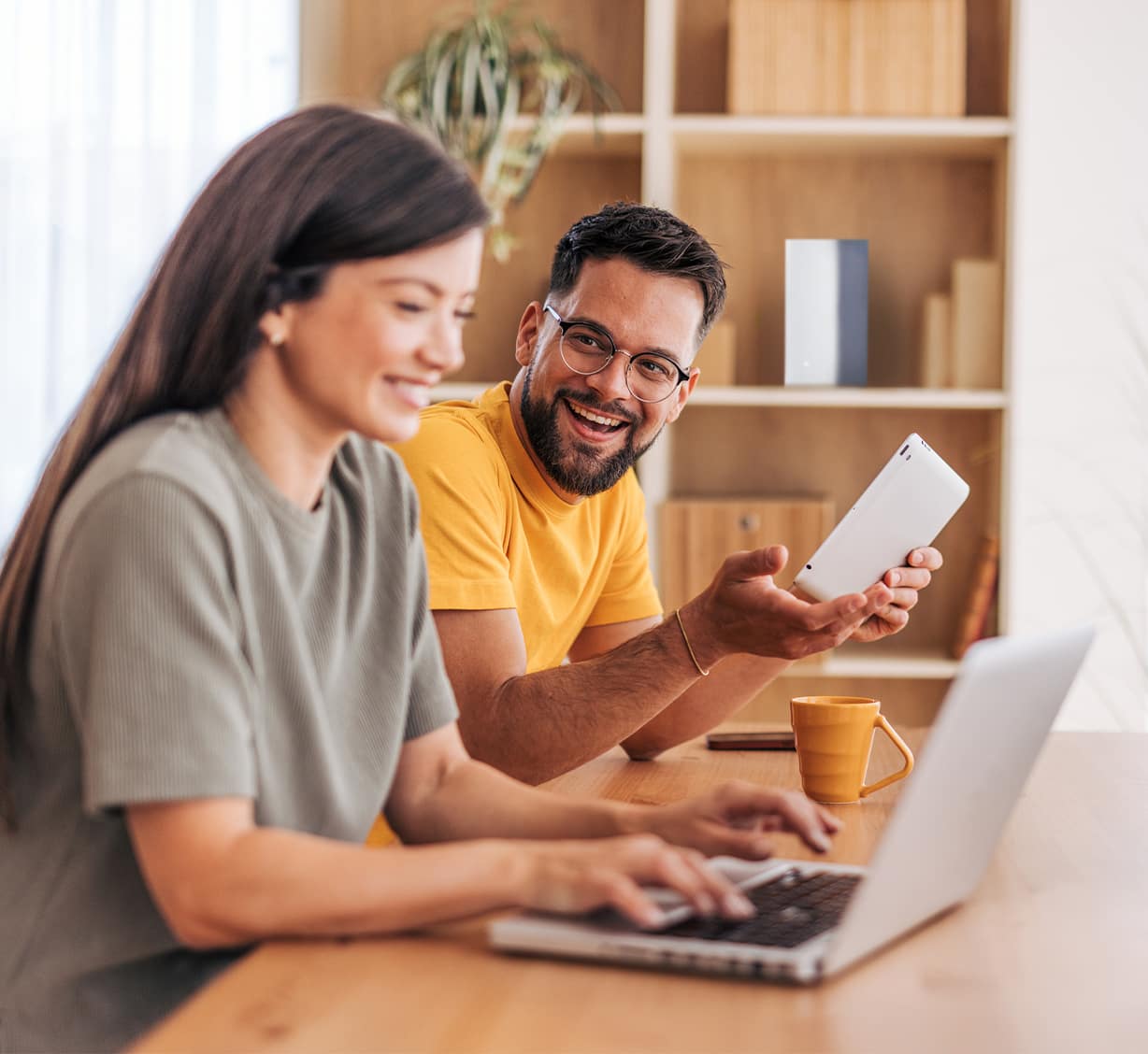 Two people enjoying their connected home with a laptop and tablet